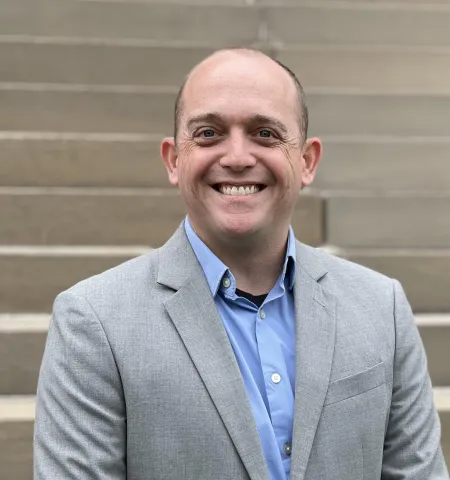 Ian Haynes standing outside by the steps of Page Hall