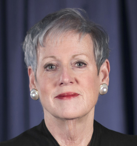 female judge with gray hair on blue background