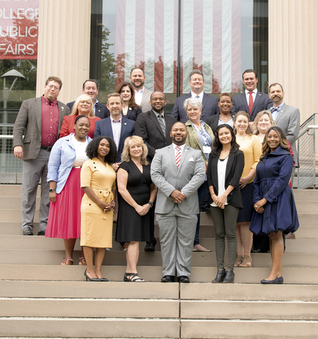 19 diverse people in business attire standing on building steps