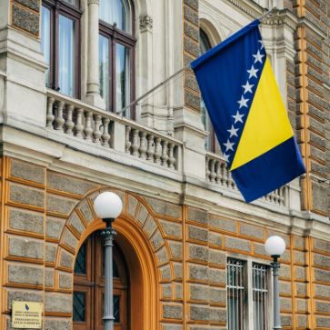 the flag of bosnia-herzegovina flying outside a building