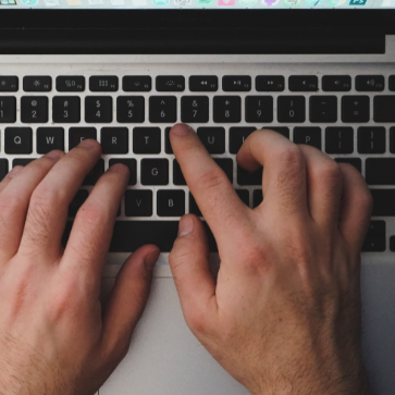 close up of hands typing on a laptop