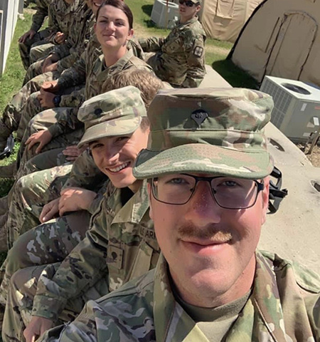 selfie photo of a line of military personnel dressed in fatigues