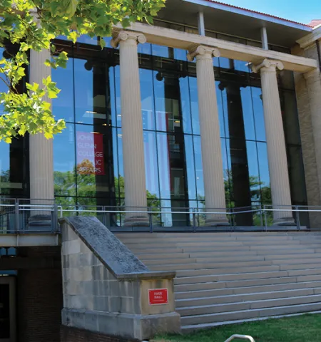 A green tree next to the front steps of Page Hall.