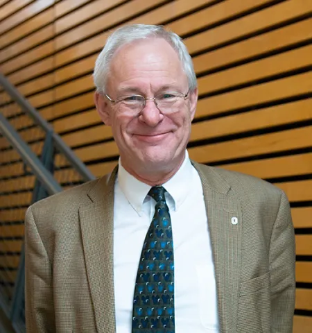 profile photo of Professor Jos Raadschelders inside a building with stairs in the background.