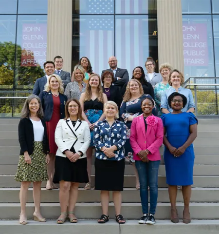 A group of elected officials from the Public Leadership Academy standing on the steps of Page Hall. 