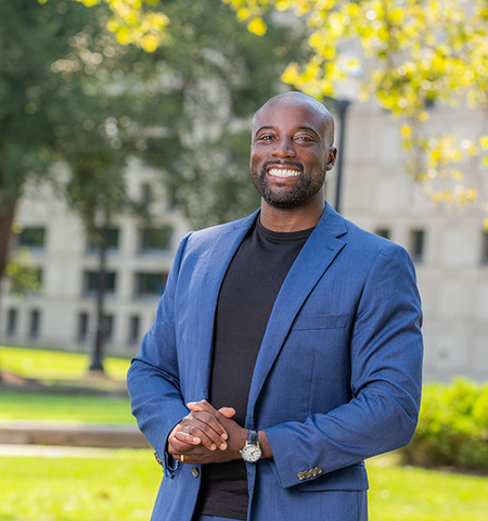Glenn College graduate Kwame Christian posing for a photo outside on campus 