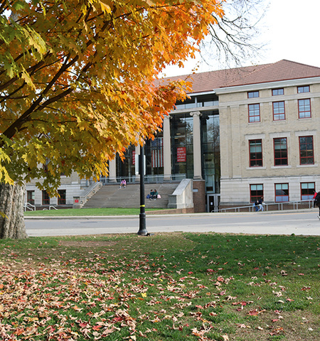 the outside of Page Hall, the home of Ohio State’s John Glenn College of Public Affairs, with a fall tree in the foreground