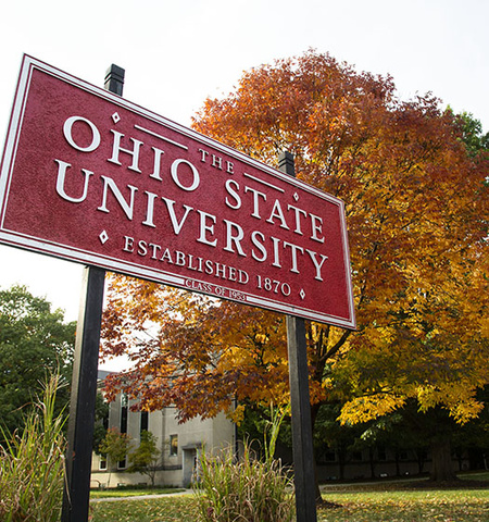 The Ohio State University campus sign with fall trees in the background