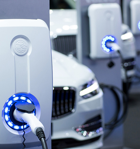 white cars plugged in to electric vehicle chargers