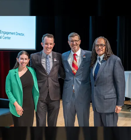 John Glenn College of Public Affairs Dean Trevor Brown (second from right) stands on a stage with the 2024 Alumni Award recipients (from left) Natalie Pantalos, BA ’13; Matthew Stephens-Rich, MPA ’14; and Ron Bridges, MA ’85