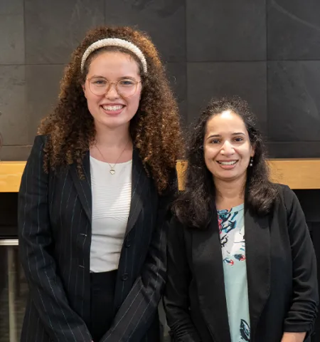 A student intern smiling next to her internship advisor.