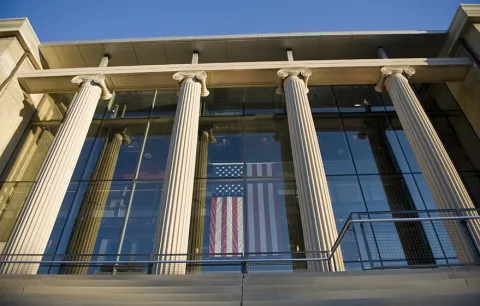 The columns at the front of Page Hall at The Ohio University with an American flag hanging in the window