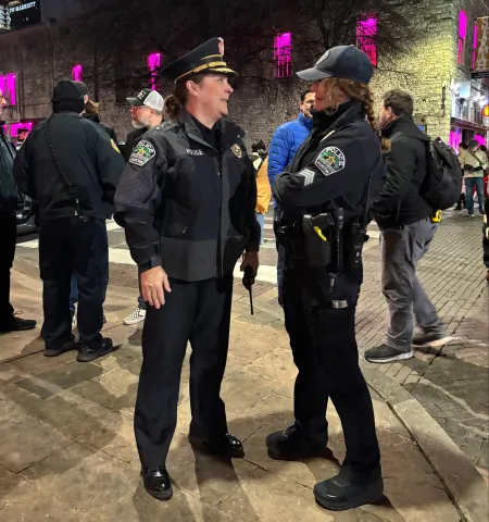 Austin Police Department Chief Lisa Davis, left, talks to former Downtown Area Command Sgt. Brandy Blake Hanna-Morris on a street corner at night.