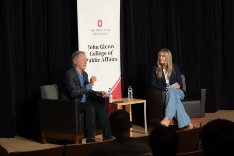 Gov. David Beasley (left) and Amanda Girth (right) sit on a stage with the audience in the foreground. 