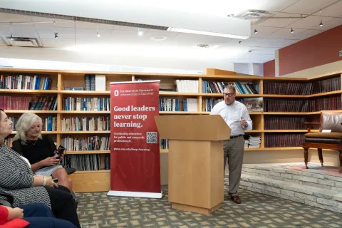 Brian Suddith standing behind a podium giving a speech